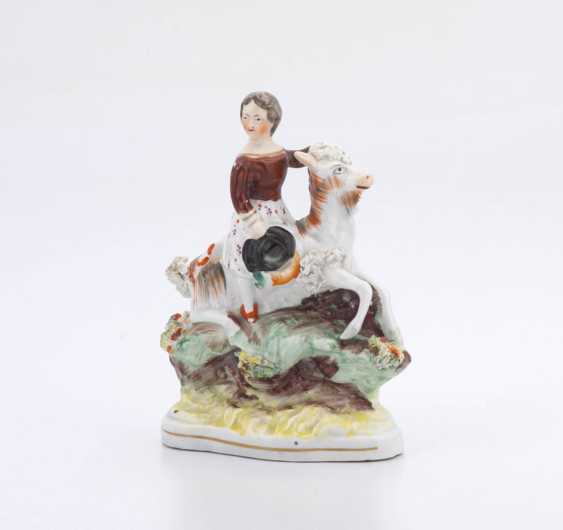 A Victorian Staffordshire figure of a young girl astride a goat
