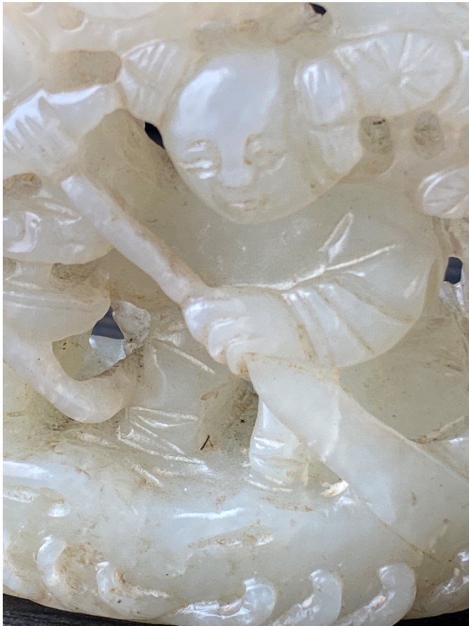 A Chinese jade pierced carving of a small boy in his boat, late 19th century