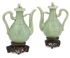 A pair of Chinese celadon-glazed ewers and covers
