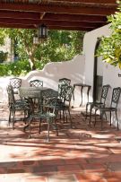 A green-painted wrought iron patio table and twelve chairs