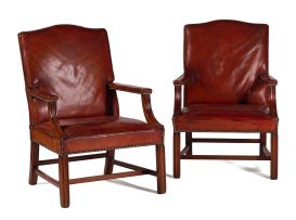 A near pair of George III style mahogany and close-nailed brown leather-upholstered library armchairs