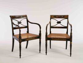 A pair of Regency black ebonised and painted armchairs