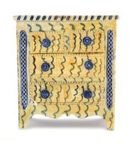 A yellow, blue and grey-glazed earthenware model of a chest of drawers