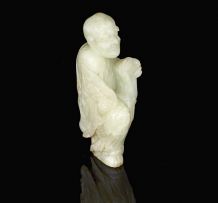 A Chinese pale celadon jade carving of a Lohan, late 19th/early 20th century