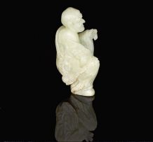 A Chinese pale celadon jade carving of a Lohan, late 19th/early 20th century