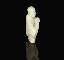 A Chinese pale celadon jade carving of a Lohan, late 19th/early 20th century