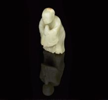 A Chinese celadon jade carving of a monk, late 19th/early 20th century