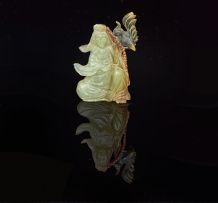 A Chinese celadon jade figure of a maiden and a bird, 20th century