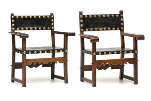 A pair of Baroque-style walnut and leather upholstered open armchairs, possibly Spanish, 19th century