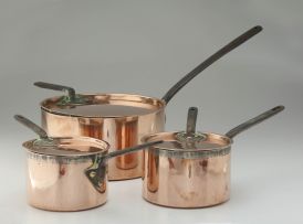 A set of three late Victorian copper and iron saucepans and covers, in sizes