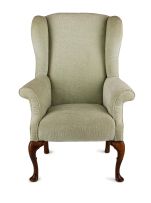 A George II style upholstered and mahogany wing-back armchair
