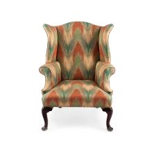 A George III walnut and upholstered wingback armchair