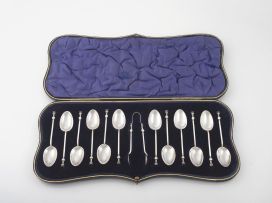 A George V silver cased set of twelve coffee spoons and a pair of sugar tongs, William Hutton & Sons Ltd, Sheffield, 1915
