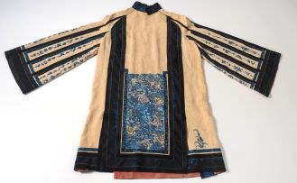 A Chinese apricot-ground and blue silk embroidered robe, Qing Dynasty, late 19th/early 20th century