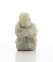 A Chinese grey jade figure of a monk holding a carp, Qing Dynasty, late 19th century
