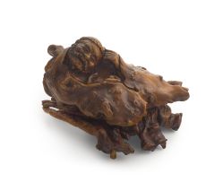 A Chinese rootwood carving of a reclining bearded monk, Qing Dynasty, late 19th century