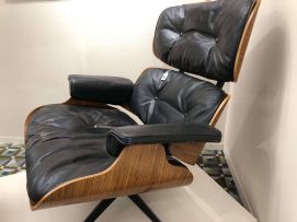 A leather and rosewood-veneered model 670 lounge chair and 671 ottoman designed in 1956 by Charles and Ray Eames