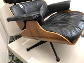 A leather and rosewood-veneered model 670 lounge chair and 671 ottoman designed in 1956 by Charles and Ray Eames