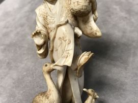 A Japanese ivory okimono goose carer, Meiji period, 1868-1912