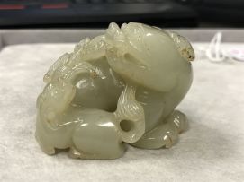 A Chinese celadon jade carving of a Buddhist lion and its pup, Qing Dynasty, 19th century