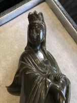 A Chinese spinach-green soapstone figure of Guanyin, Qing Dynasty, 19th century