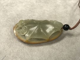 A Chinese celadon jade pendant, Qing Dynasty, 19th century